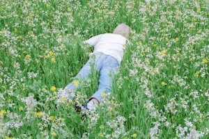 "Nurture" album cover person laying in green field