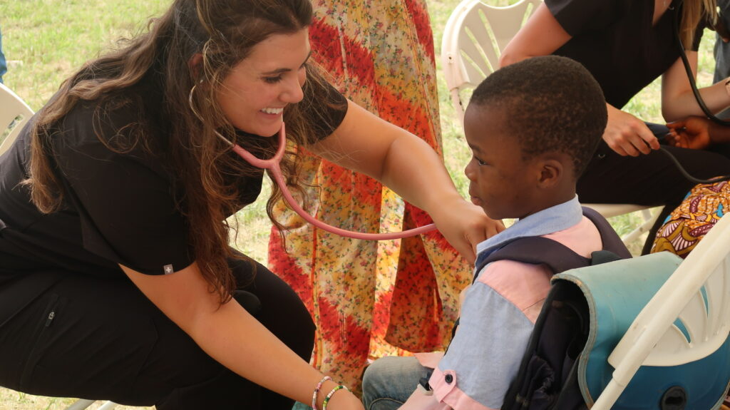 Emma Pickens in Ethiopia during a medical mission trip taking a child’s heartbeat. Photo courtesy of Pickens.

